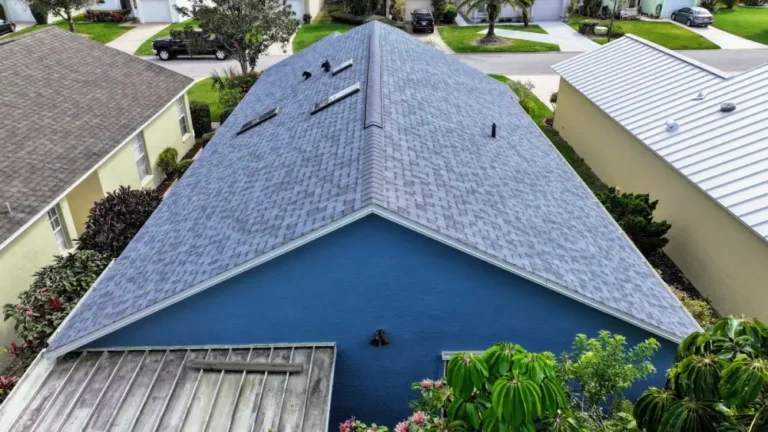Blue house with new gray shingle roof in residential neighborhood